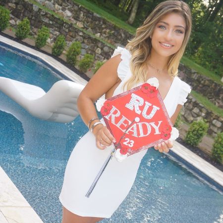 Giu Giudice in a white dress poses for a picture in front of a swimming pool.